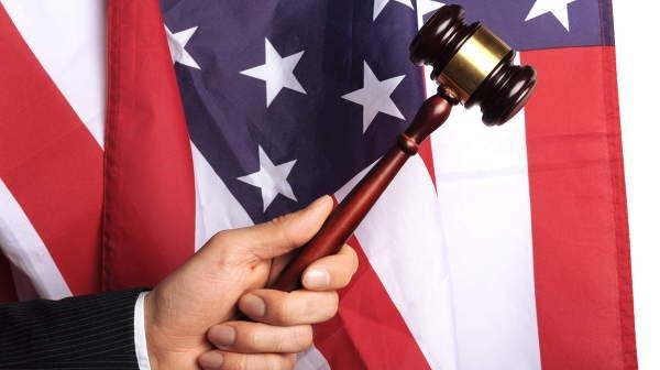 Молоточек судьи Верховного федерального суда США на фоне флага США