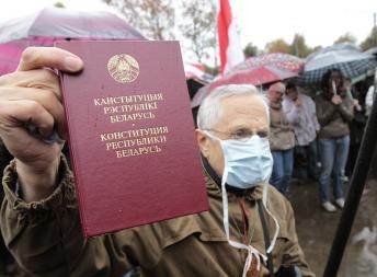 Участник Народного схода оппозиции в Минске с Конституцией Республики Беларусь 8 октября 2011