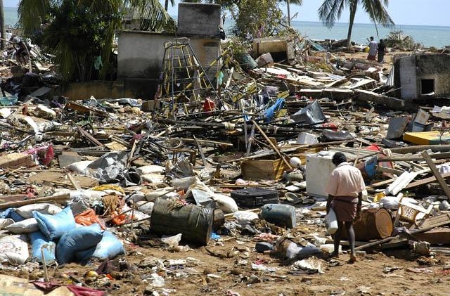 1.19 Люди осматривают руины после цунами, которое возникло в результате подводного землетрясения.