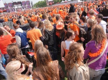32. Голландские люди в оранжевом для празднования Дня Королевы в Амстердаме